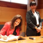 Niubó, signant al llibre d’honor de l’Ajuntament de Gavà davant l’atenta mirada de Badia