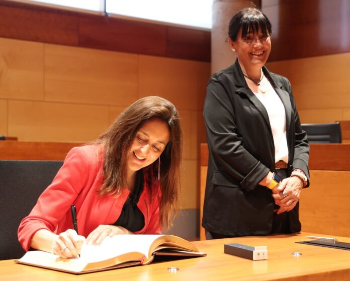 Niubó, signant al llibre d'honor de l'Ajuntament de Gavà davant l'atenta mirada de Badia Niubó